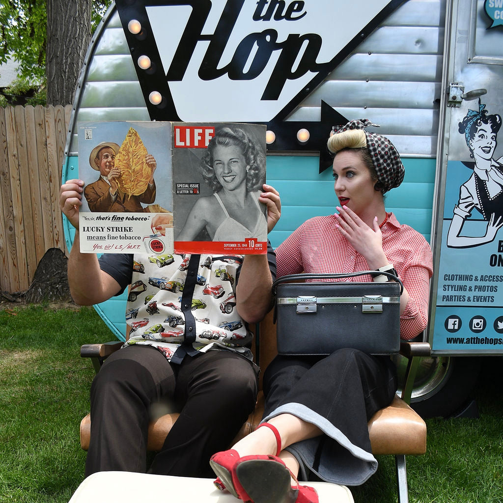 The Hop vintage shop selling 1940's and 1950's vintage clothing.  Man in retro bowling shirt and women in a vintage top, sailor pants, vintage shoes and a Tootie's Turban.